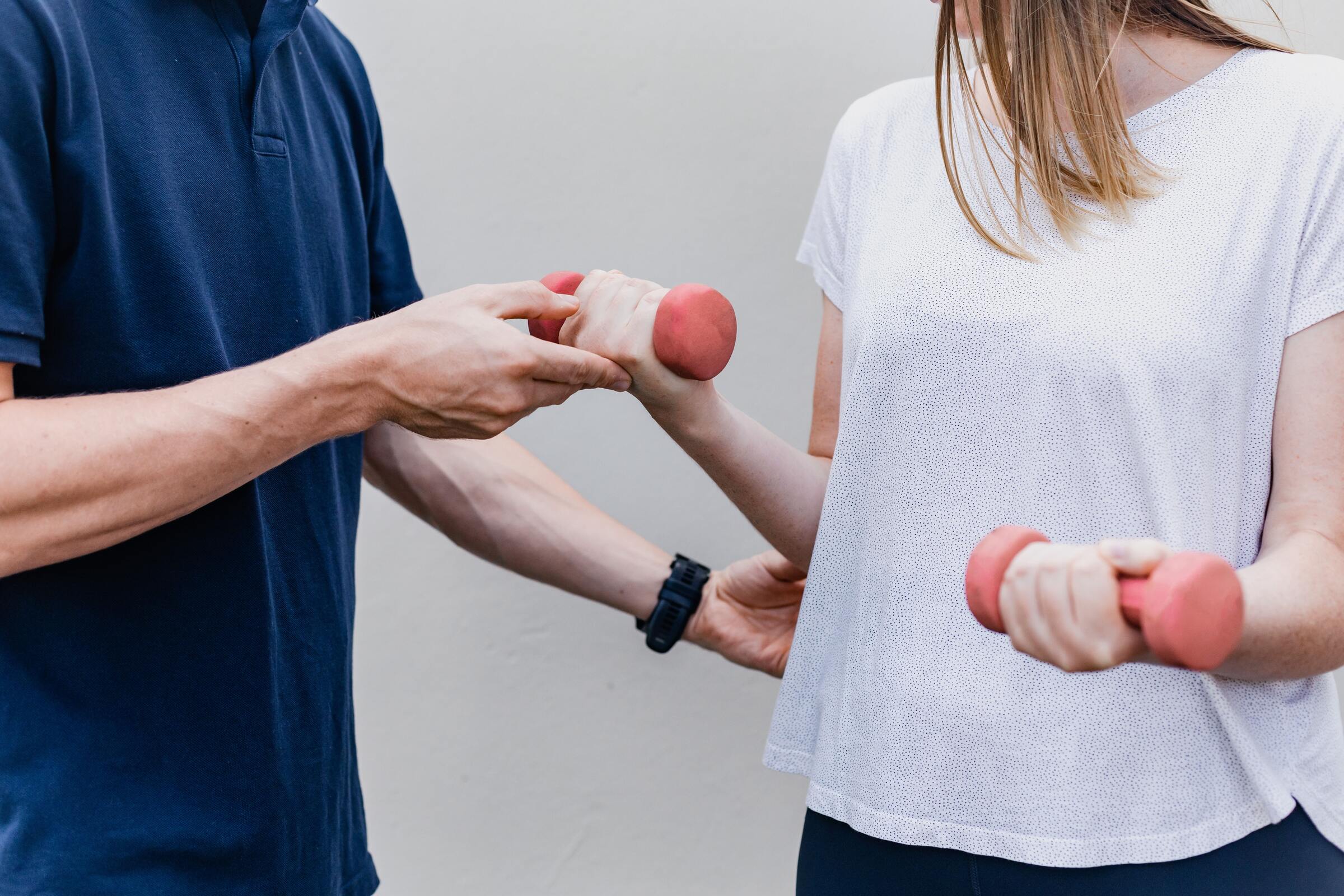 A physical therapist guiding a patient through an arm exercise